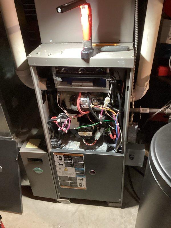 Performed standard HVAC tune-up inspection on residential furnace system, including removal of access panels for thorough examination of internal components, wiring connections, and circuit boards. Inspected surrounding utility connections and PVC ventilation pipes for proper installation and operation. All systems functioning within normal parameters with no issues identified.