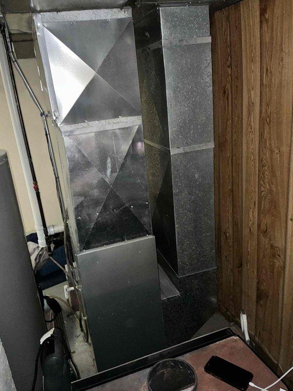 Completed installation of new HVAC ductwork system in residential utility area, including installation of galvanized sheet metal rectangular trunk line with proper transitions and junction boxes. All seams were properly sealed with metal tape, and the system was integrated with existing PVC ventilation pipe while ensuring proper connections to the air handler/plenum assembly.