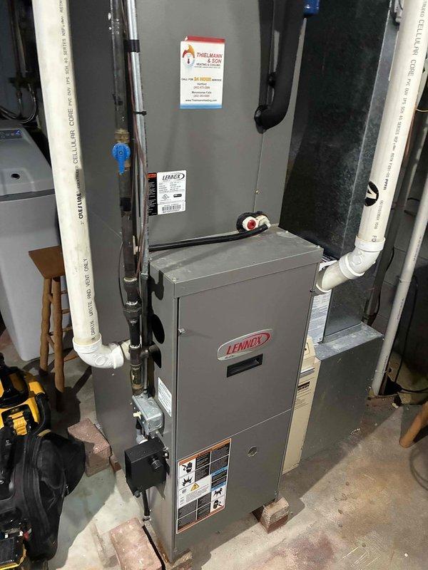 Completed a routine annual maintenance tune-up on a Lennox furnace system located in the utility room. Inspected all components and connections including the ventilation PVC piping, electrical connections, and mounting structure. Identified corrosion damage in the lower cabinet corner, likely due to moisture accumulation, and documented with photos for reference. System is operational but recommend monitoring the rust progression in the cabinet area.