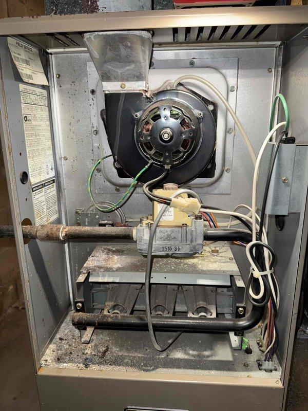 Conducted assessment of aging furnace unit showing significant dust accumulation and wear on internal components including blower motor, wiring, and gas valve assembly. Identified condensation issues on ductwork in basement utility area, indicating potential humidity control problems. Recommended complete HVAC system replacement to address efficiency concerns and prevent future moisture-related complications.