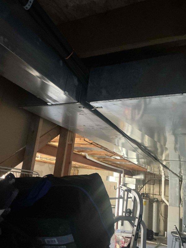 Conducted evaluation of existing HVAC system in utility room, documenting condition of ductwork and water heating equipment. Assessed metal ductwork mounting and connections for potential replacement, noting current system configuration and spatial requirements for new installation.
