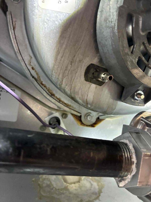 Performed inspection of mechanical equipment showing significant corrosion and wear. Identified rust formation at metal bracket connection points and deterioration around valve assembly with copper fitting. Documented condition of threaded pipe connections and wire routing for further assessment and repair planning.