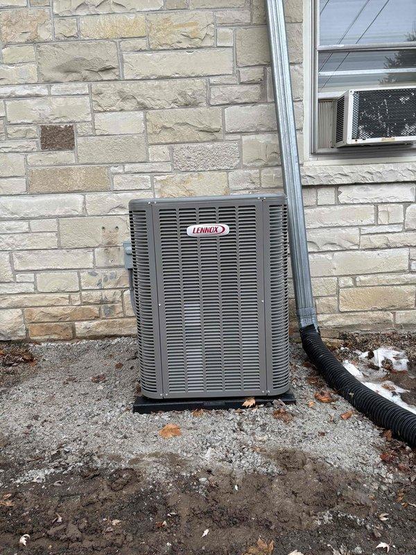 Completed installation of a new Lennox AC complete system at customer's residence. Installed outdoor condensing unit on a proper gravel bed foundation and mounted electrical disconnect box on exterior stone wall with protective conduit runs. Connected all electrical and refrigerant lines according to manufacturer specifications, ensuring proper system operation.