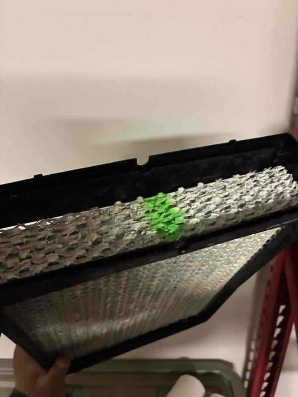 Performed indoor air quality service including inspection and replacement of AprilAire filter. Removed existing filter which showed visible contamination (green spot on metallic surface), indicating proper filtration was occurring but replacement was necessary. Installed new filter to maintain optimal IAQ and system efficiency.