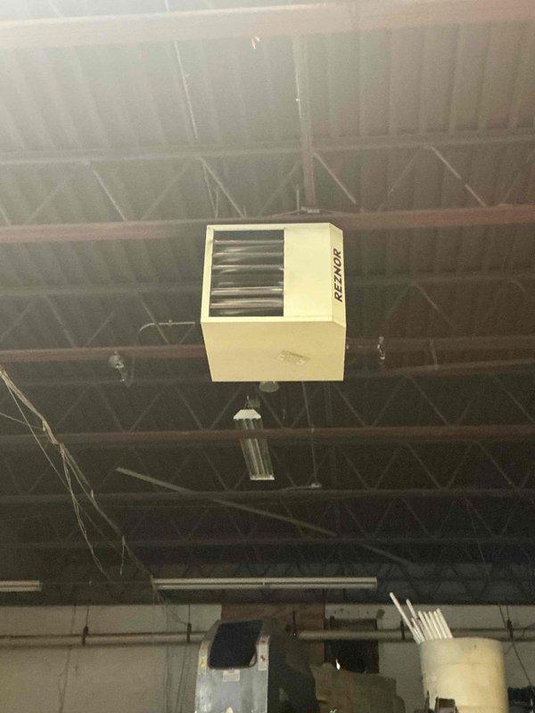 Conducted inspection of the commercial space with an existing Reznor ceiling-mounted unit heater. Space evaluation revealed a high-ceiling industrial/commercial facility with exposed structural trusses, existing ductwork, and storage/workspace areas. Provided estimate for replacement of the aging heating system with comparable BTU capacity unit suitable for the open commercial environment.