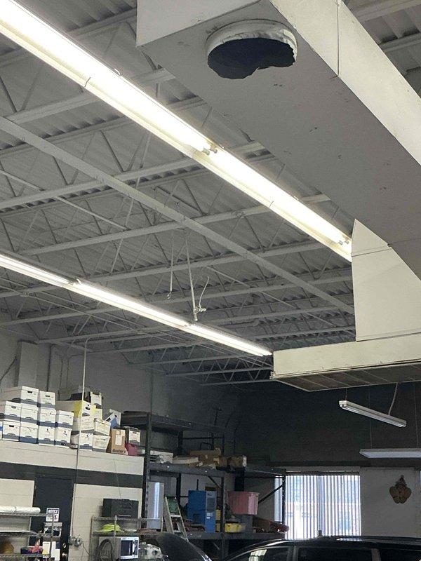 Conducted inspection of the commercial space with an existing Reznor ceiling-mounted unit heater. Space evaluation revealed a high-ceiling industrial/commercial facility with exposed structural trusses, existing ductwork, and storage/workspace areas. Provided estimate for replacement of the aging heating system with comparable BTU capacity unit suitable for the open commercial environment.