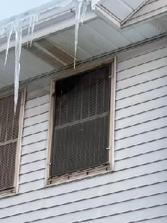 Conducted inspection of Goodman furnace system in utility closet area. Identified significant ice damming and icicle formation along roof edge, indicating potential heat loss issues. Recommended improved attic insulation and ventilation to prevent future ice dam formation that could lead to water intrusion and system inefficiency.