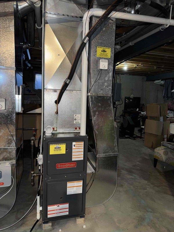 Responded to no-heat call for aging Goodman furnace system located in basement. Upon inspection, identified clogged condensate drain line and failing ignition control module causing heat failure. Cleaned drain line, replaced ignition module, and tested system through multiple heating cycles to confirm proper operation with normal flame characteristics and adequate airflow through ductwork.