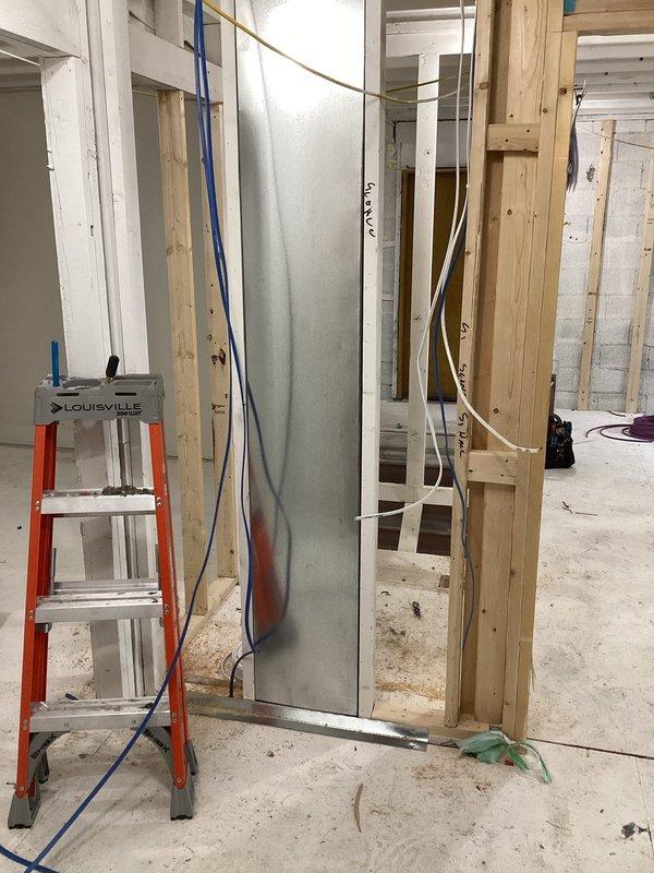 Completed installation of insulated cylindrical metal ductwork in exposed ceiling area, properly securing between wooden joists during ongoing renovation. System was carefully integrated with existing electrical components while maintaining proper clearances in the construction zone.