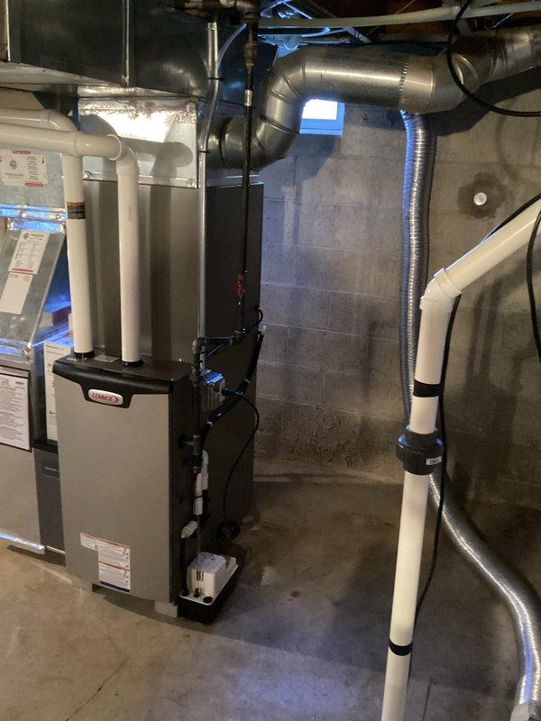 Completed installation of a new Lennox furnace system in basement utility room with proper PVC ventilation piping. Performed system pressure testing with digital manometer (model MA-12838A) to verify proper operation. Installed complete ductwork including flexible and rigid metal ducts for efficient air distribution throughout the building.