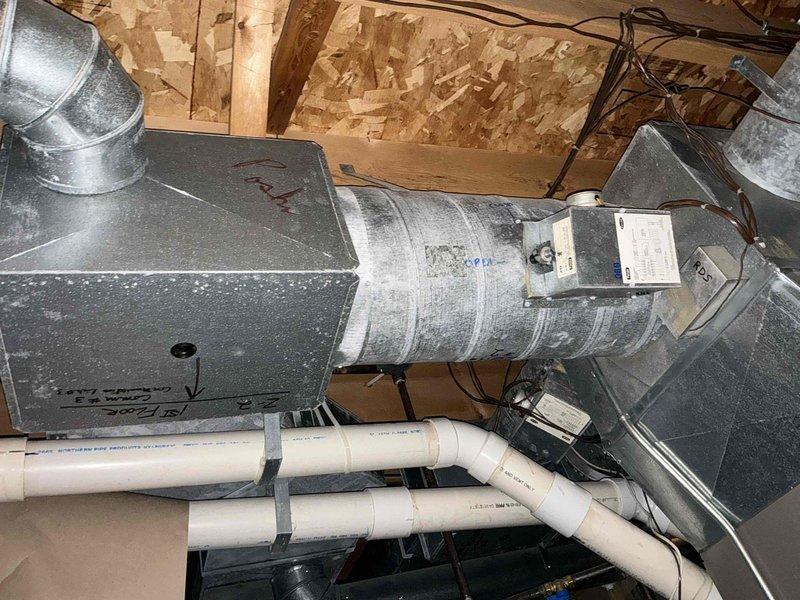 Completed replacement of an aging HVAC system in the attic/crawl space area, installing new air handling unit with properly insulated ductwork and PVC condensate drain lines. System installation included connecting all necessary junction boxes, securing proper electrical connections, and ensuring proper ventilation through the existing rectangular sheet metal ducting in the basement/utility area.