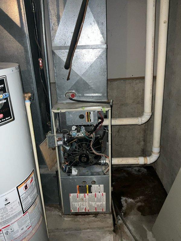 Conducted an assessment of an aging Carrier WeatherMaker 9200 furnace system in the basement utility room. The unit was opened for inspection, revealing potential issues with internal components including fan motor, electrical wiring, and control board. Recommended complete system replacement due to age and efficiency concerns.