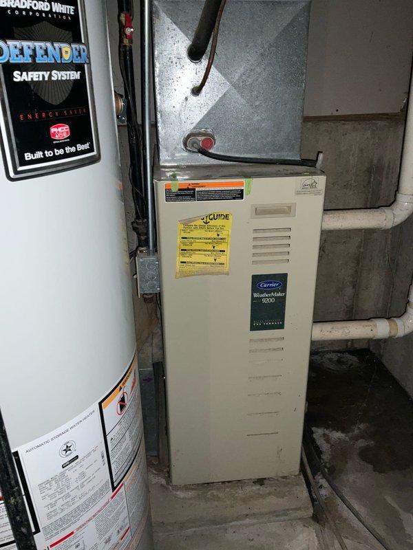 Conducted an assessment of an aging Carrier WeatherMaker 9200 furnace system in the basement utility room. The unit was opened for inspection, revealing potential issues with internal components including fan motor, electrical wiring, and control board. Recommended complete system replacement due to age and efficiency concerns.