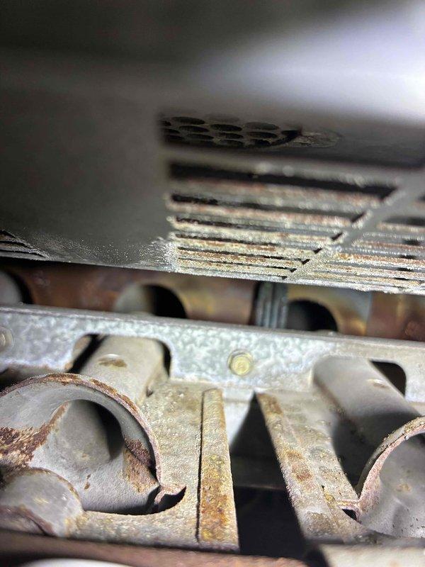 Conducted combustion analysis on heating system using Testo 310 II analyzer, revealing critical safety concerns including dangerously elevated carbon monoxide levels (5450 ppm) and signs of significant heat exchanger deterioration. Visual inspection confirmed severe corrosion and rust damage to the heat exchanger components, indicating immediate replacement is necessary to prevent carbon monoxide leakage into living space.