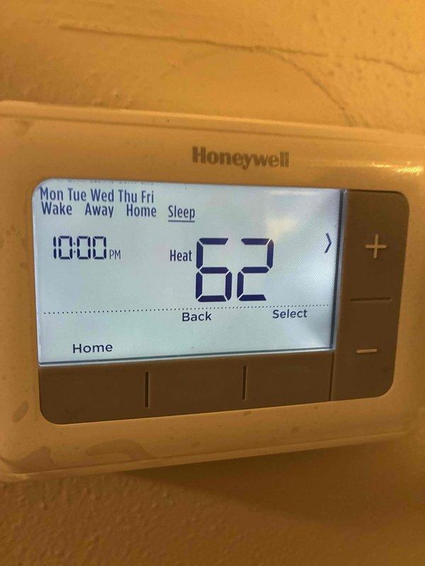 Completed thermostat inspection and programming check on Honeywell digital programmable thermostat. Verified proper operation of heat mode, confirmed temperature settings were correct at 62°F for evening and 66°F for morning, and validated scheduled programming functionality across weekday settings.