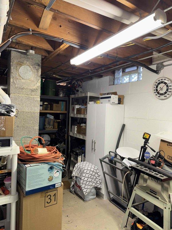 Performed routine tune-up service on HVAC system in basement utility room. Inspected ceiling-mounted ductwork and accessible components. Observed PVC Coreline pipe installation running between joists, which appears to be properly secured and in good condition. No immediate concerns identified with visible system components.