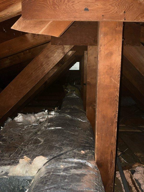 Conducted comprehensive inspection of attic space to evaluate HVAC replacement requirements. Examined existing ductwork condition and insulation quality, noting areas where flexible insulated ducts were installed. Assessed structural clearances and support beams to determine optimal positioning for new system components.
