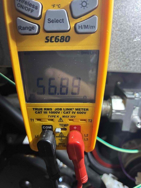 Performed routine HVAC tune-up service including inspection of filtration system and electrical diagnostics. Examined metallic air filter for accumulated particulates and measured system voltage parameters (56.89V) using Fieldpiece SC680 multimeter with thermocouple probes. System operational within normal parameters after service completion.