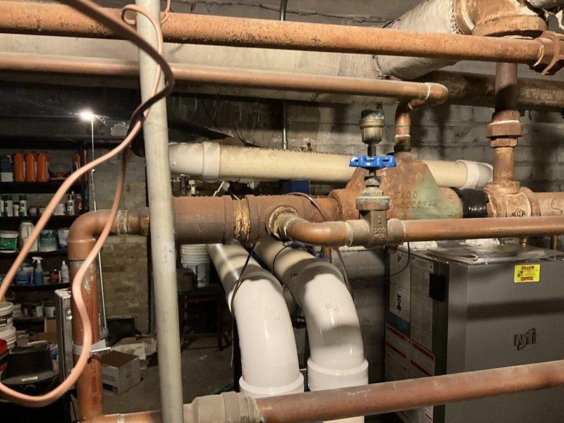 Conducted complete assessment of aging heating system in basement mechanical room. Identified significant corrosion on copper supply/return lines, deteriorated main valve assembly with rust development, and outdated circulation pump with failing digital control panel. Recommended full replacement of hydronic system components including piping infrastructure and control devices to prevent imminent system failure and improve operational efficiency.