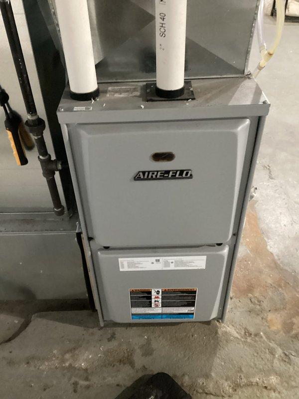Performed comprehensive tune-up service on an AIRE-FLO furnace system in basement. Opened unit to inspect internal components including control board, wiring harnesses, and motor assembly. Verified proper function of ventilation system with particular attention to the PVC exhaust pipes and gas line connections.
