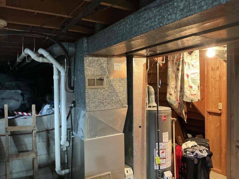 Performed comprehensive inspection of existing HVAC system in basement utility area. Evaluated aging furnace unit with connected ductwork, noting deterioration and inefficiency. Recommended complete system replacement to improve energy efficiency and reliability, with proper sizing of new equipment to match home's heating and cooling requirements.
