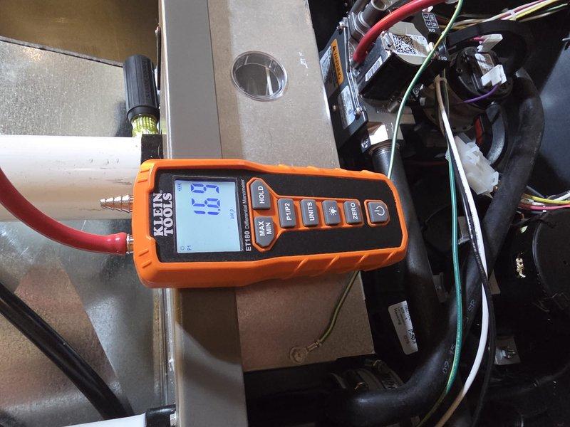 Completed installation of a new furnace system with proper venting configuration. Installed and connected PVC exhaust pipes in an "h" pattern on exterior wall per manufacturer specifications. Conducted electronic system testing with Klein Tools meter showing operational efficiency factor (EF) of 15, confirming proper startup and functionality of the new unit.