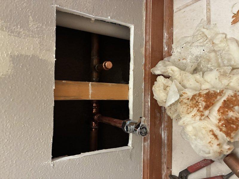 Accessed wall opening to inspect copper supply plumbing and shutoff valve. Performed necessary repairs to address leaking valve issue, then verified proper water flow and pressure to bathroom toilet. All connections were tested for leaks, and system is now functioning correctly.