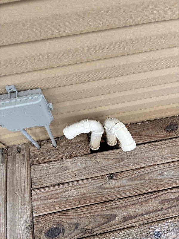 Performed furnace inspection and maintenance on aging unit with access panel removed. Inspected internal components, wiring connections, and ventilation system. Examined exterior PVC drainage pipes and confirmed proper installation and function. Unit shows normal wear with minor dust accumulation but is operating within specifications after service.