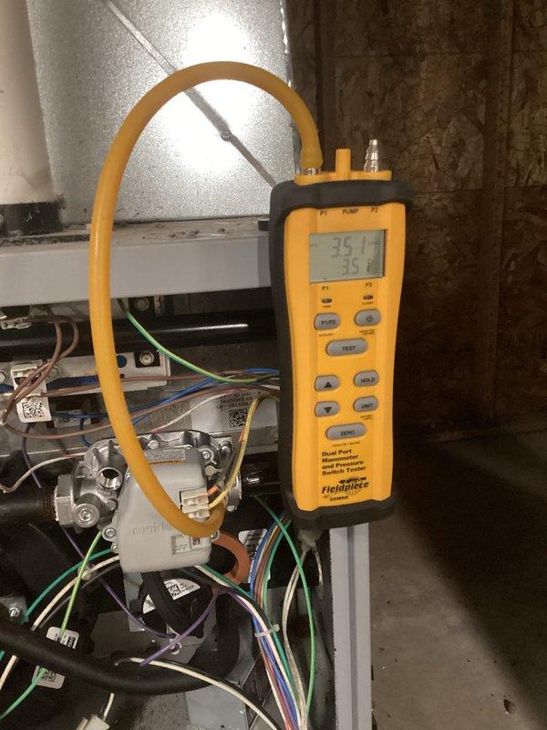 Diagnosed no-heat complaint on aging system using Fieldpiece manometer, which confirmed low pressure readings of 35.1 across inducer assembly. Inspected blower compartment and found significant dust accumulation on fan motor assembly affecting airflow. Cleaned blower wheel, verified proper operation of safety switches, and restored heat function to manufacturer specifications.