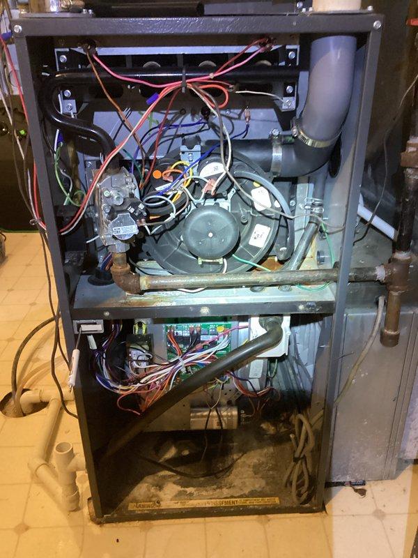 Performed annual maintenance agreement service on residential HVAC furnace system. Inspected interior components including blower motor, electrical control boards, and wiring connections. Observed signs of corrosion on metal housing base that may require monitoring at next scheduled maintenance.