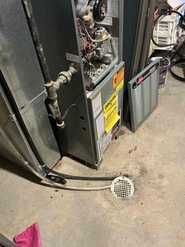 Completed installation of a Bosch HVAC system in residential basement setting, including furnace unit with proper gas line connection and ventilation. System features integrated ductwork with both round and rectangular sections, and all electrical components were properly wired and tested for optimal performance. Installation meets all safety requirements with appropriate floor drainage system in place.