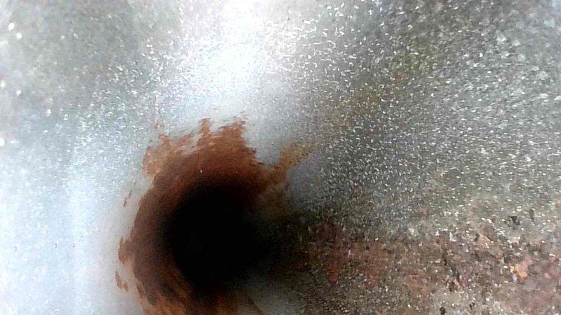 Performed scheduled HVAC tune-up, checking system temperature with digital thermometer (reading 77.9°F). Identified corrosion and rust formation around heat exchanger opening, indicating potential moisture intrusion or early-stage deterioration. Documented condition for monitoring during next maintenance visit.