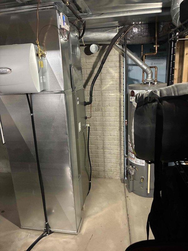 Conducted comprehensive assessment of existing HVAC system in residential utility room, identifying aging Carrier furnace unit requiring replacement. Documented current installation featuring metal ductwork, connected humidifier, and proximity to water heater for proper replacement planning. Prepared estimate for complete system replacement with appropriately sized equipment to integrate with existing ductwork configuration.