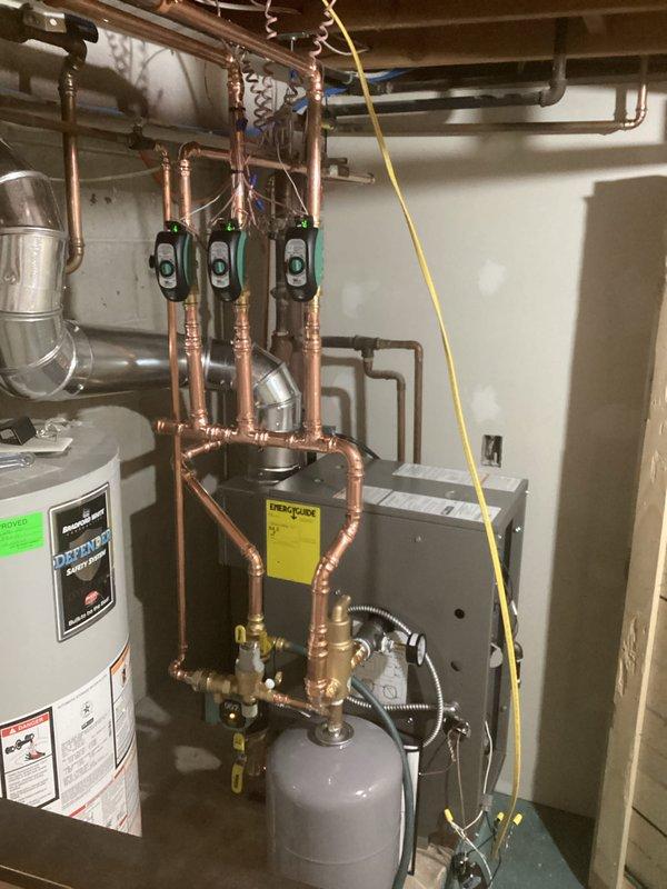 Installed new high-efficiency boiler system with three circulator pumps in parallel configuration. Completed all copper piping connections between boiler, domestic water heater, and existing distribution system. Mounted expansion tank and verified proper system pressure and operation after installation.