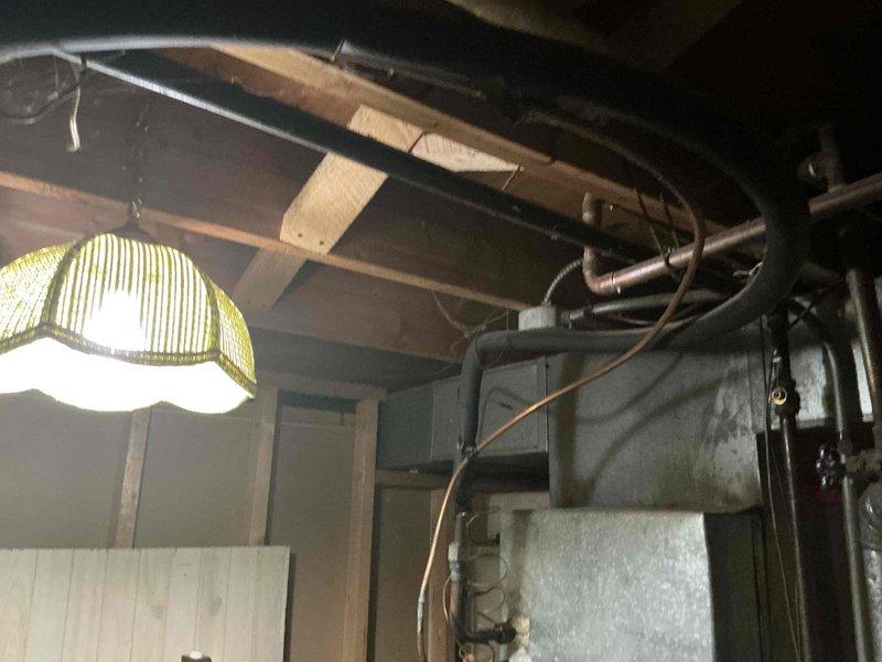 Conducted inspection of basement HVAC system components showing significant age and potential efficiency concerns. Evaluated existing copper piping connections and galvanized metal ductwork, noting visible wear and possible inadequate ventilation. Recommended complete replacement of the current system with properly sized equipment to improve energy efficiency and reliability.
