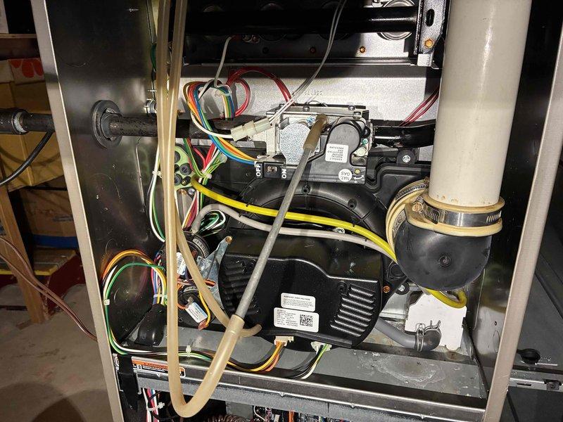 Performed comprehensive HVAC tune-up service including inspection of furnace interior components, blower assembly, and electrical connections. Verified proper operation of motor and examined all wiring connections (red, yellow, green, white, and blue) for secure attachment and signs of wear. Inspected PVC condensate drain and exhaust connections, confirming proper sealing at rubber coupling points and checking for any blockages or leaks.