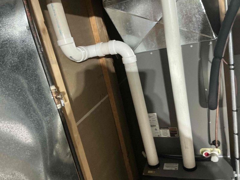 Performed comprehensive inspection of residential HVAC and plumbing systems in unfinished utility area, focusing on IAQ improvement opportunities. Documented existing installation including PVC drainage pipes, copper supply lines, and black insulated HVAC ductwork. Identified areas requiring modification to optimize indoor air quality performance with current system configuration.