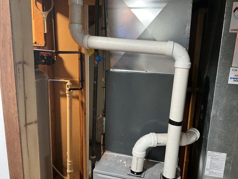 Conducted full inspection of existing HVAC system, including furnace/air handler unit with compromised filter and ductwork. Documented PVC drainage system configuration with multiple right-angle connections. Recommended complete system replacement based on observed efficiency issues and age-related wear of components.
