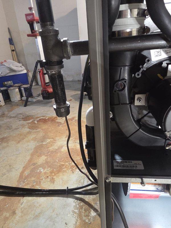 Completed installation of a new HVAC complete system with proper mechanical connections and pipe fittings in the utility area. System was pressure tested using Klein Tools ET180 Differential Manometer, which registered 170 on the scale, confirming proper system pressure within manufacturer specifications.