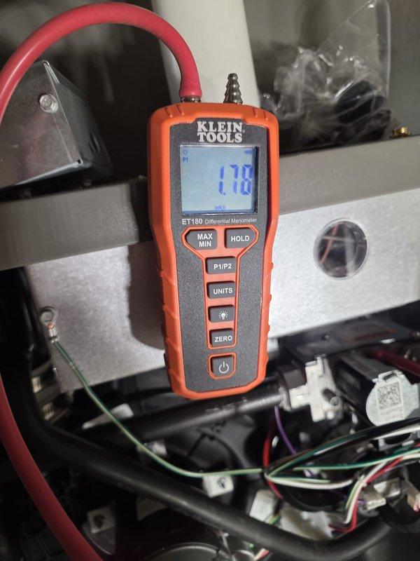 Completed installation of a new HVAC complete system with proper mechanical connections and pipe fittings in the utility area. System was pressure tested using Klein Tools ET180 Differential Manometer, which registered 170 on the scale, confirming proper system pressure within manufacturer specifications.
