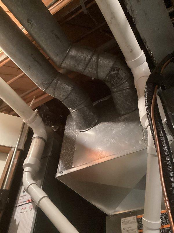 Performed routine tune-up inspection of the HVAC system, examining ductwork, plumbing connections, and air handler unit in the mechanical room. Inspected galvanized sheet metal ducts, PVC pipe connections, and copper piping for proper installation and functionality. All components were found to be in good working order with no visible damage or leaks detected.