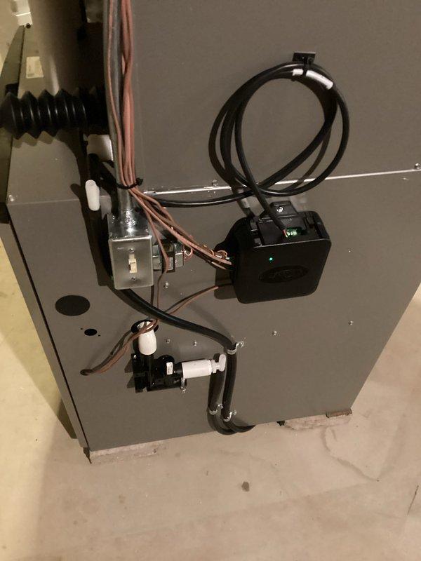 Completed installation of a complete HVAC system with proper electrical connections and wiring to the control module (verified green indicator light functioning). Installed exterior components including PVC ventilation/drainage pipes along the wall and connected the outdoor unit with appropriate refrigerant lines and electrical connections (yellow, red, and blue wires) to ensure proper communication between indoor and outdoor units.