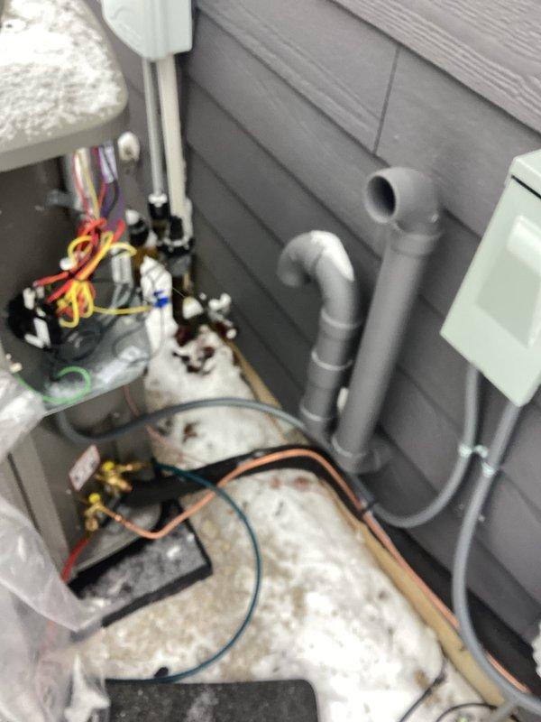 Completed installation of a complete HVAC system with proper electrical connections and wiring to the control module (verified green indicator light functioning). Installed exterior components including PVC ventilation/drainage pipes along the wall and connected the outdoor unit with appropriate refrigerant lines and electrical connections (yellow, red, and blue wires) to ensure proper communication between indoor and outdoor units.