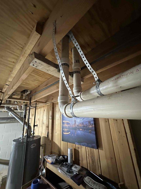 Conducted assessment of existing HVAC system in unfinished basement with exposed PVC piping, ductwork, and structural elements. Identified aging furnace unit requiring replacement. Documented current installation configuration including metal ductwork runs, connections, and surrounding mechanical components to prepare comprehensive replacement estimate.