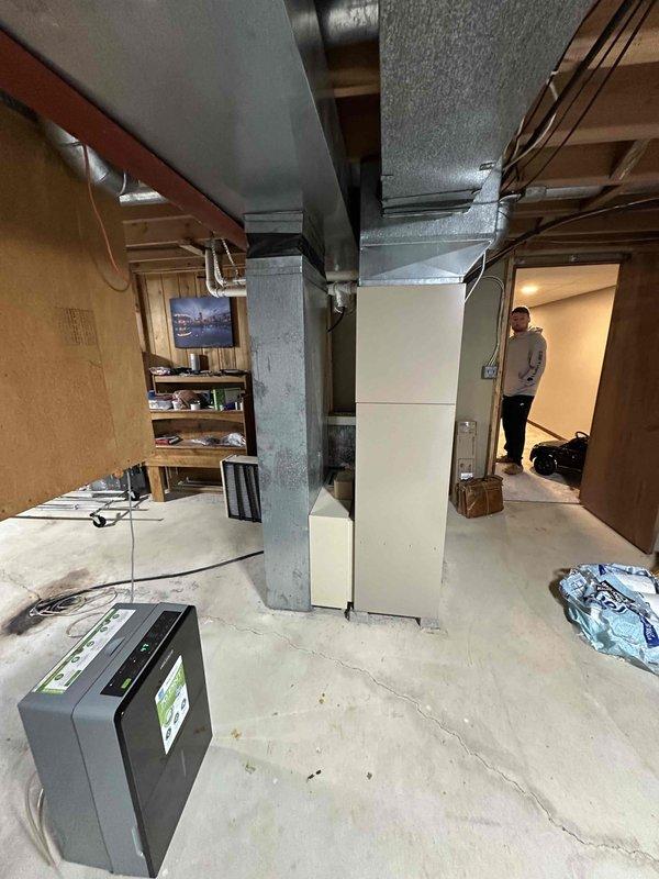Conducted assessment of existing HVAC system in unfinished basement with exposed PVC piping, ductwork, and structural elements. Identified aging furnace unit requiring replacement. Documented current installation configuration including metal ductwork runs, connections, and surrounding mechanical components to prepare comprehensive replacement estimate.