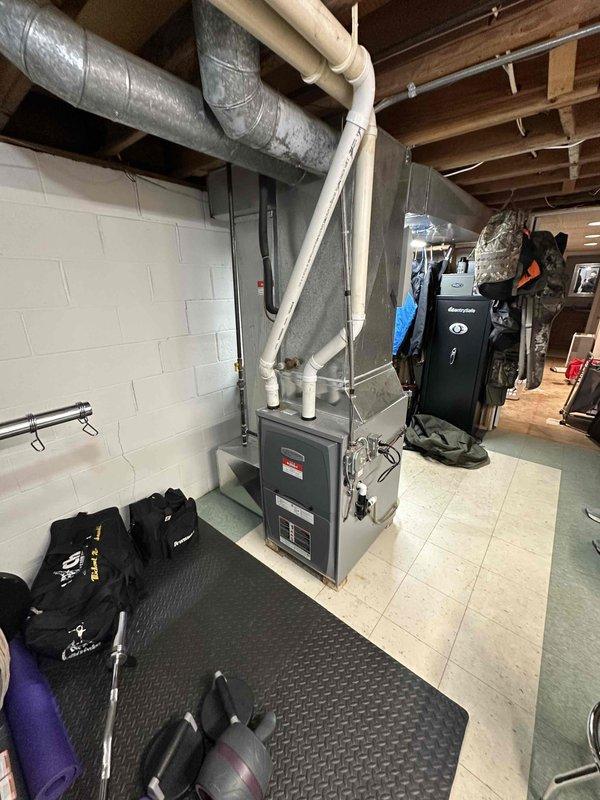 Conducted site assessment for HVAC replacement. Current system observed in basement utility area with existing furnace connected to PVC ventilation pipes and metal ductwork. Exterior inspection revealed snow-covered conditions with existing outdoor condenser unit covered for winter protection. Replacement recommendation provided based on evaluation of current installation configuration.