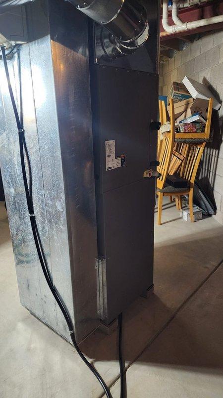 Successfully installed a new furnace unit in the basement utility room, properly connecting it to the existing ductwork and power supply. Noted frost formation on the adjacent cooling component which will require future monitoring to prevent potential system inefficiency.