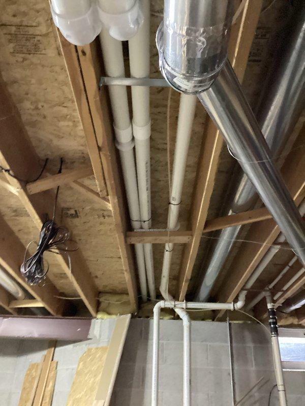 Performed comprehensive tune-up on residential HVAC system, focusing on furnace inspection in basement utility area. Examined exposed ductwork and PVC venting connections for proper installation and integrity. Inspected furnace internal components including wiring array and Honeywell control box, verifying proper electrical connections and operational status.