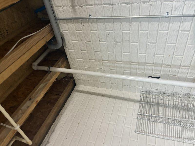 Conducted inspection of existing sump pump installation in basement. System includes circular basin with black lid, PVC discharge piping connected to drainage system, and visible electrical connections. Assessed condition of surrounding concrete floor and moisture barriers on foundation walls. Provided estimate for recommended upgrades to improve basement flood protection.