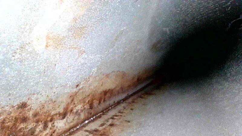 Performed routine HVAC tune-up and identified significant corrosion and rust formation along metal seams in the unit. Documented extensive discoloration and deterioration at critical junction points that may indicate moisture intrusion or ongoing water damage requiring attention in the near future.